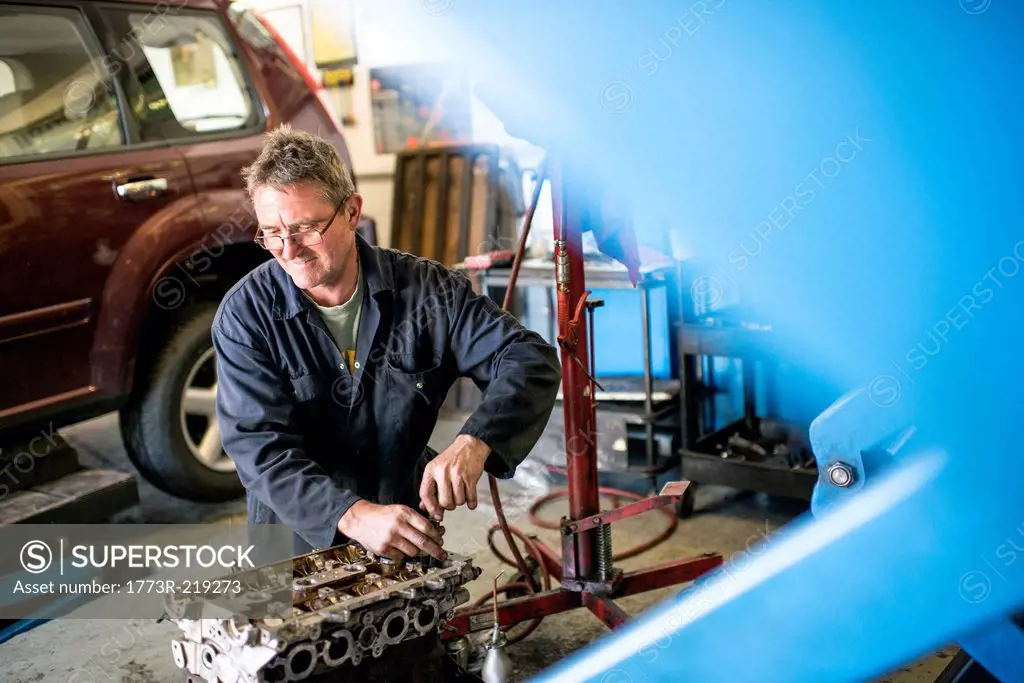 Mechanic working on car parts in garage
