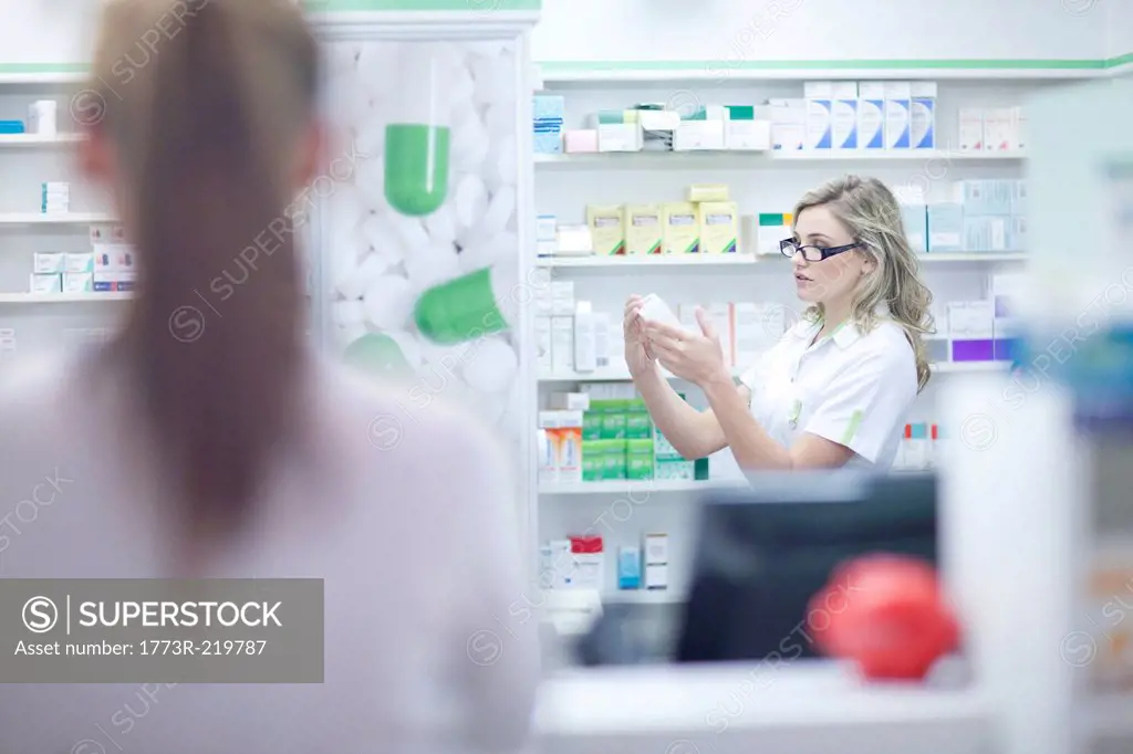 Pharmacist looking at box of medication