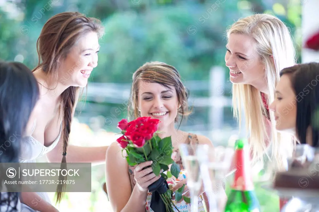 Young woman and friends with bunch of roses