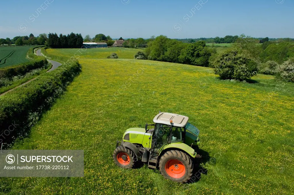 Tractor working in green fields