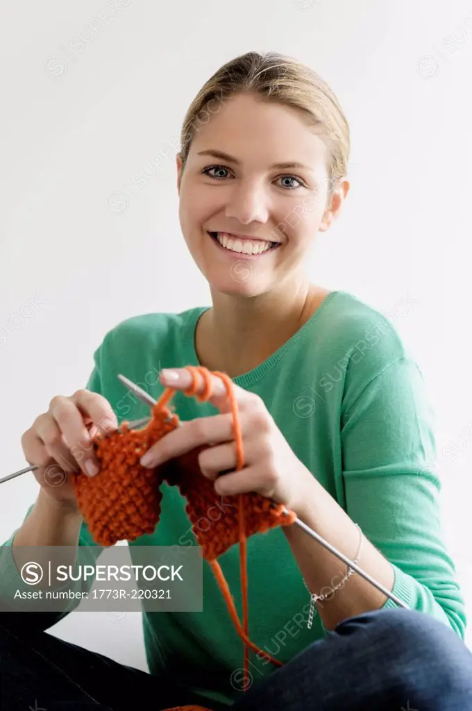 Portrait of young woman knitting
