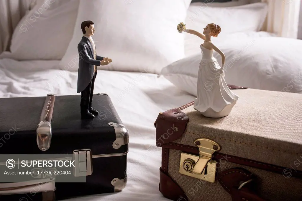 Wedding figurines on separate suitcases