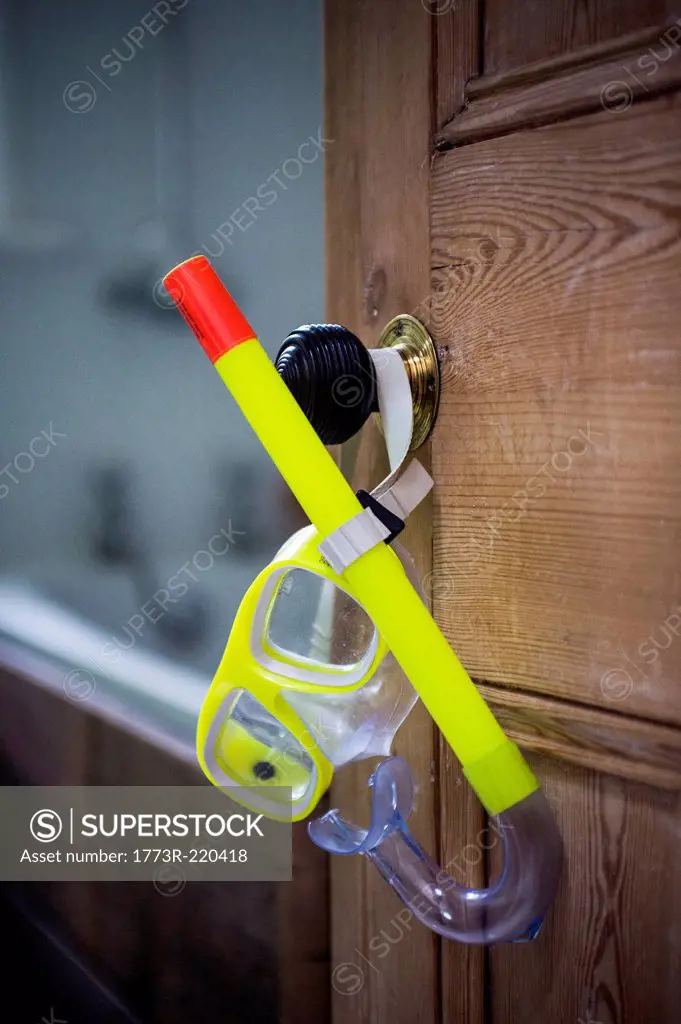Open bathroom door with hanging snorkel and goggles