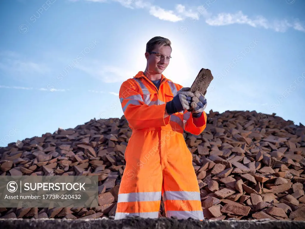 Worker in reflective clothing inspecting pig iron