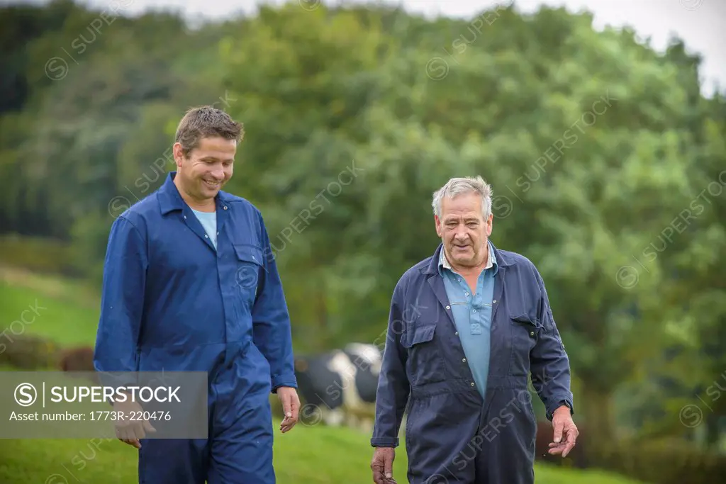 Farmer and son walking together in field