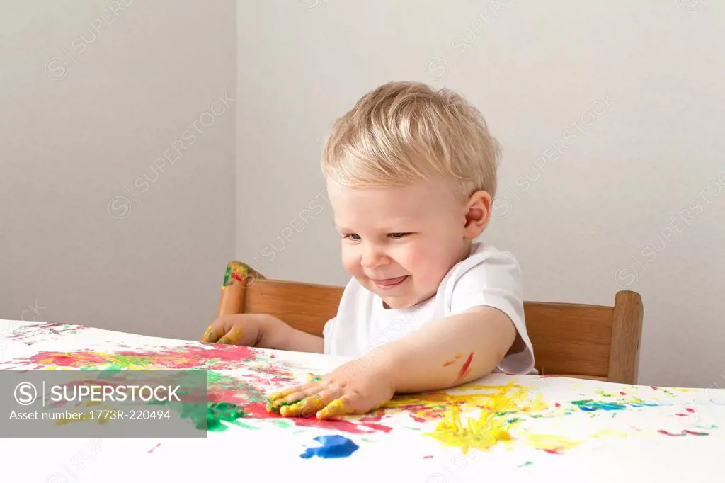 Little boy playing with finger paints