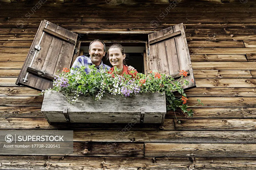 Portrait of couple at chalet window, Achenkirch, Tyrol, Austria