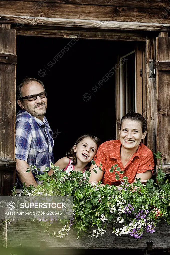 Portrait of family at chalet window, Achenkirch, Tyrol, Austria