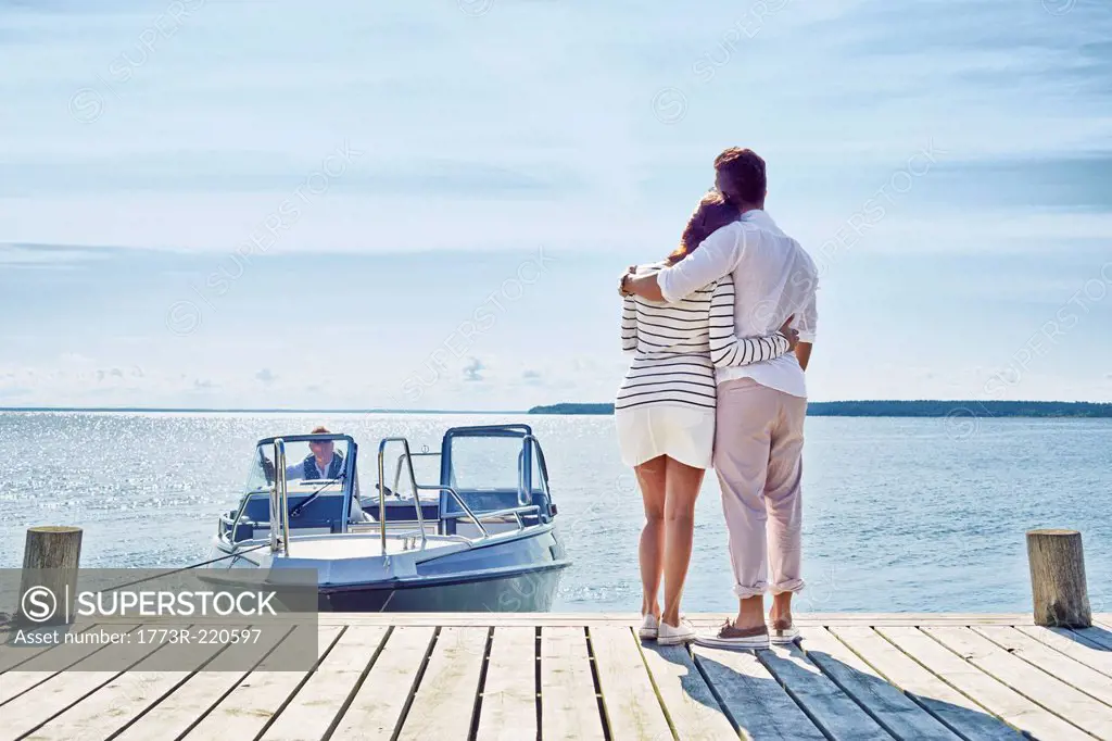 Young couple on pier looking at view, Gavle, Sweden