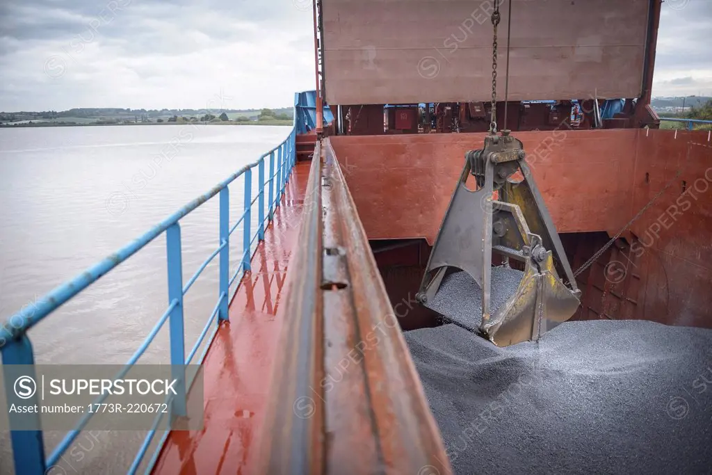 Grab unloading metal alloy from ship's hull