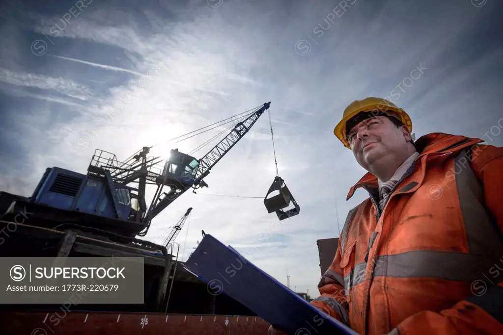 Low angle view of load master checking ship loading