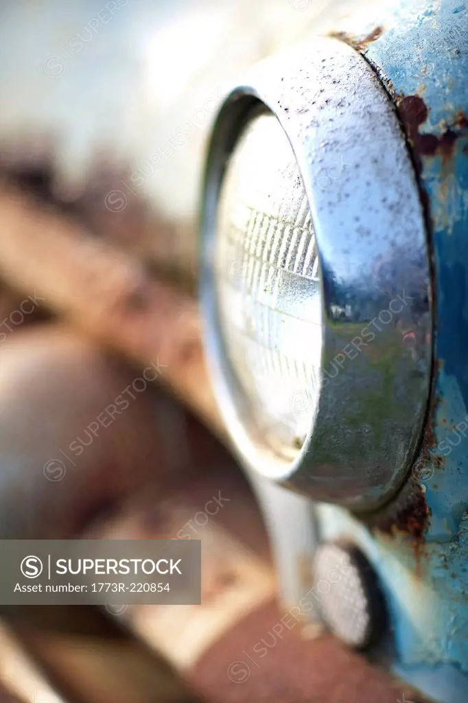 Side view of rusty car headlight and bumper