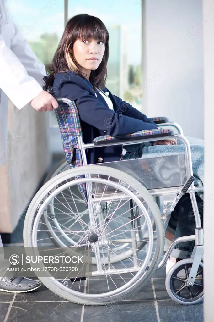 Woman in wheelchair assisted by male nurse