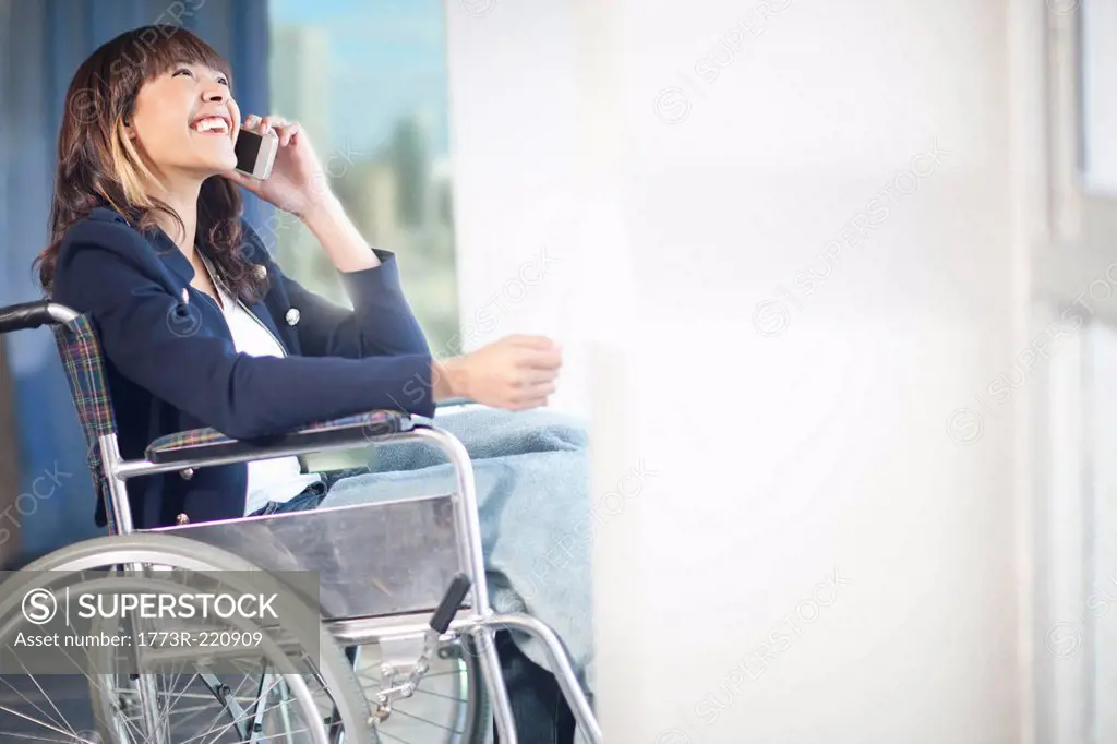 Woman in wheelchair using mobile phone