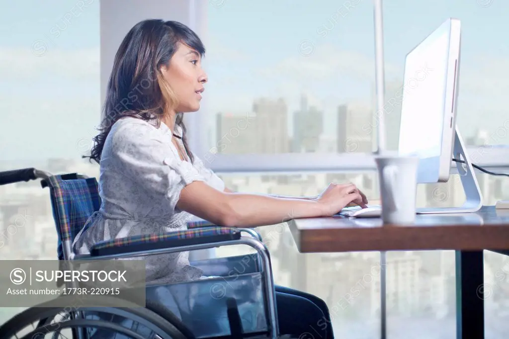 Woman in wheelchair using computer