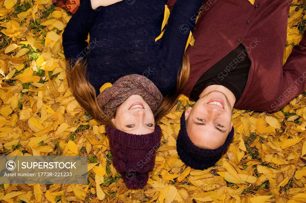 Young couple lying in autumn leaves