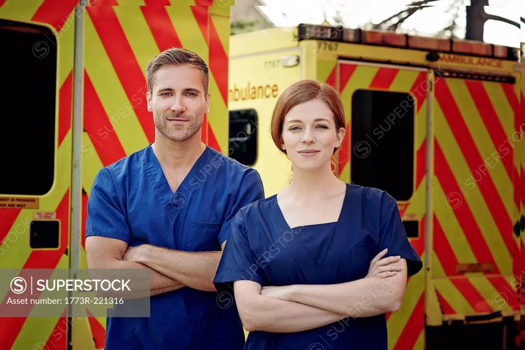 Portrait of two emergency medical technicians next to ambulance