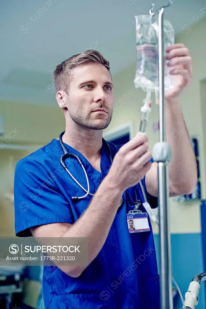 Doctor adjusting intravenous drip in hospital