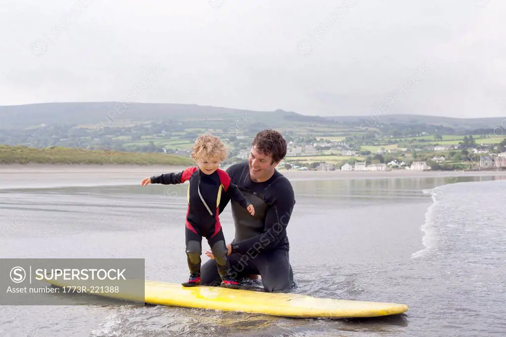 Father teaching son how to surf