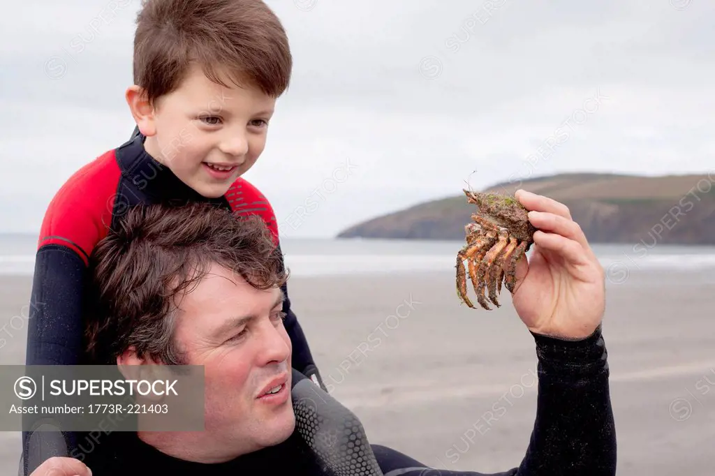 Father holding crab with son