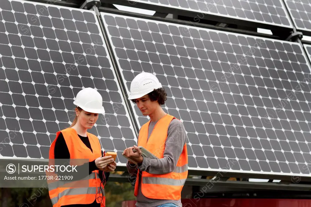 Man and woman working on photo voltaic panels