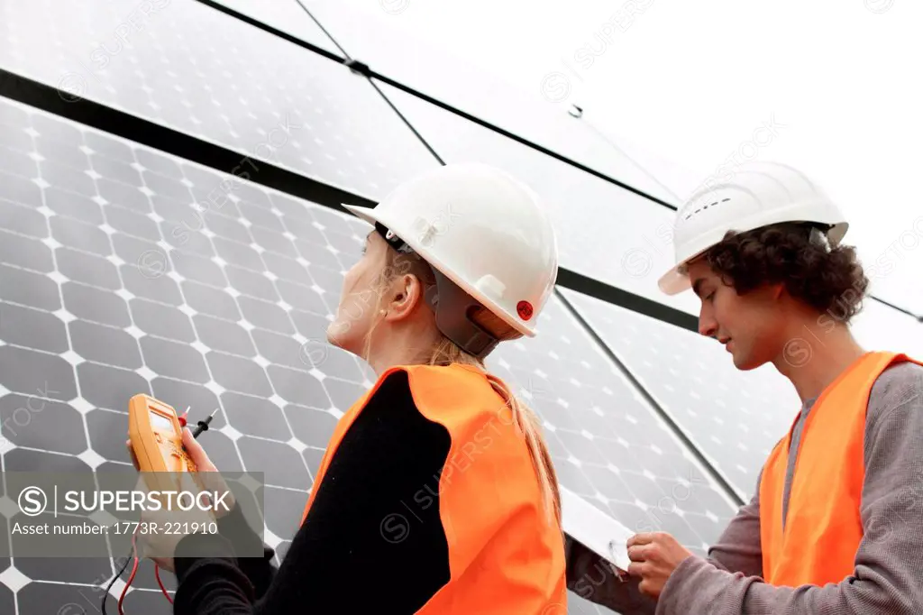 Man and woman working on photo voltaic panels
