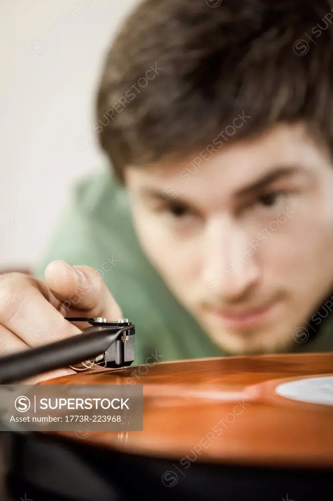 Young man playing vinyl record, close up