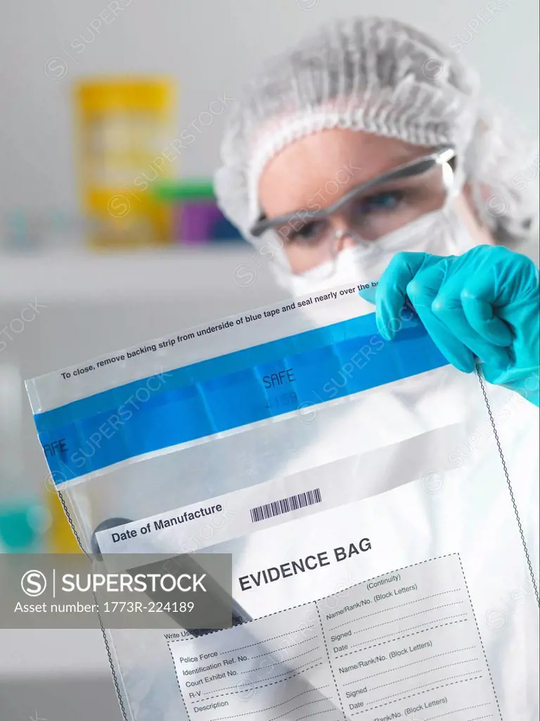Forensic scientist holding evidence bag from crime scene in laboratory