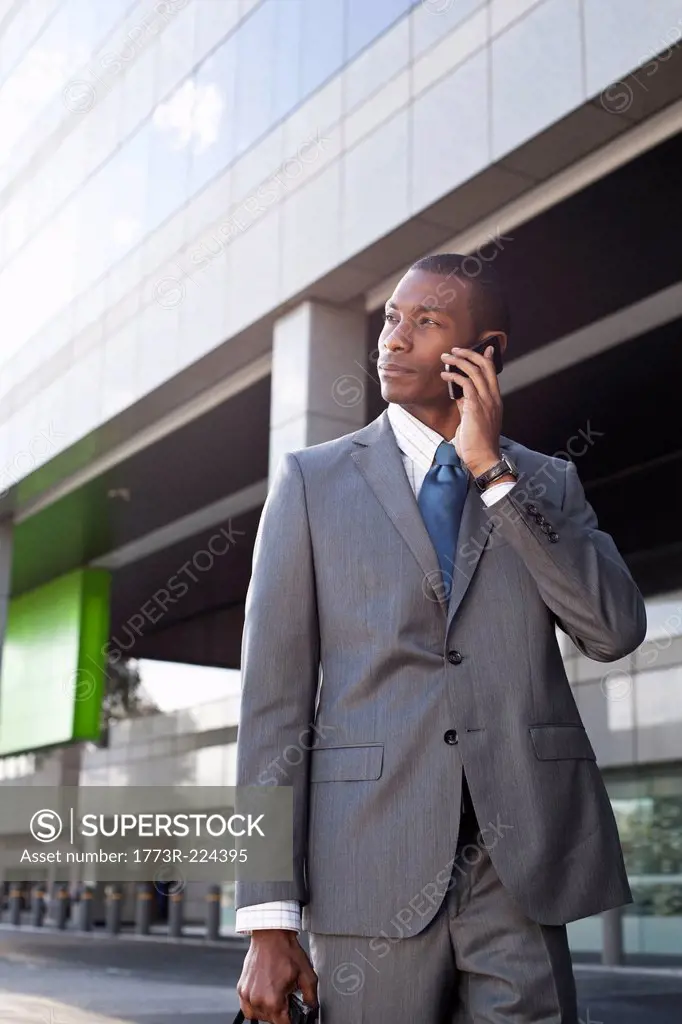 Businessman standing outside making phone call