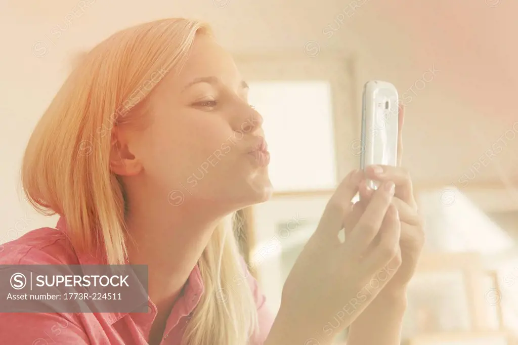 Young woman taking self portrait photograph using smartphone