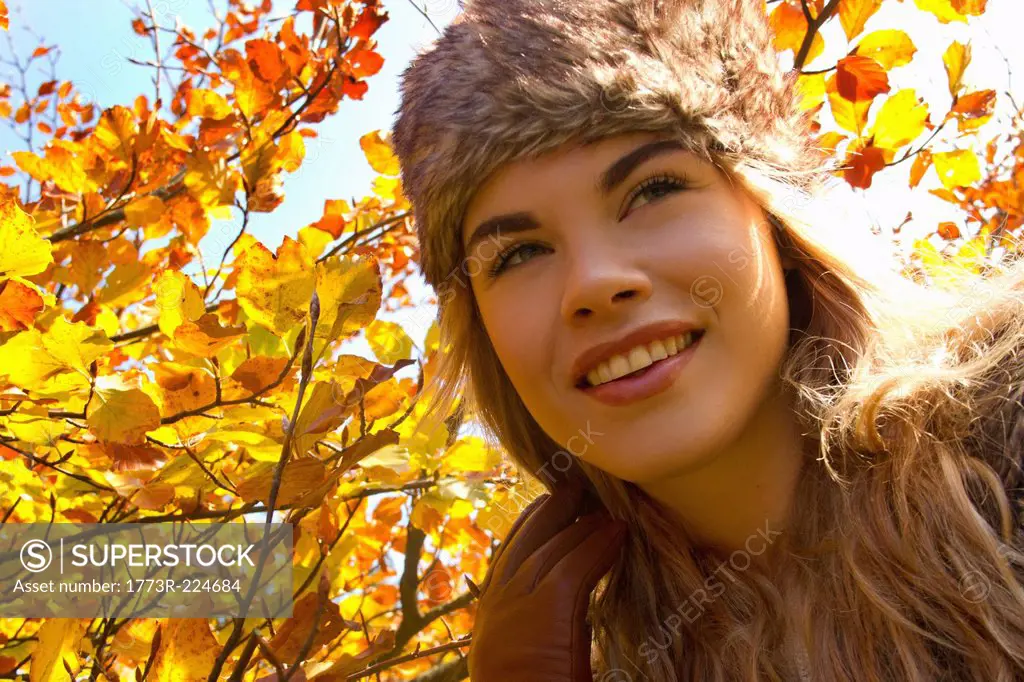 Young woman in fur hat in autumnal park