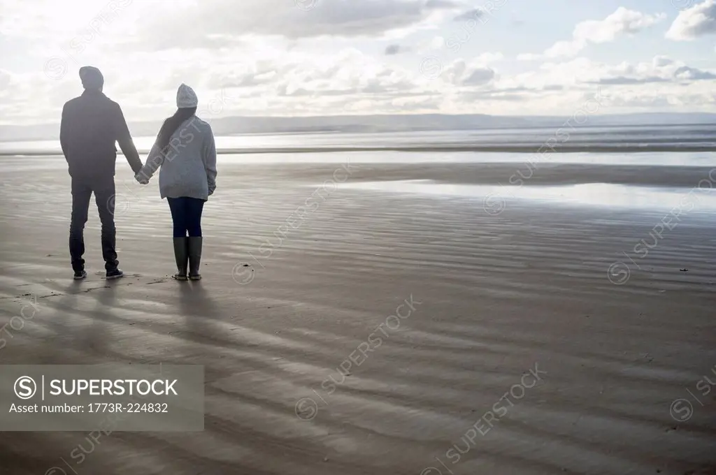 Young couple holding hands, Brean Sands, Somerset, England