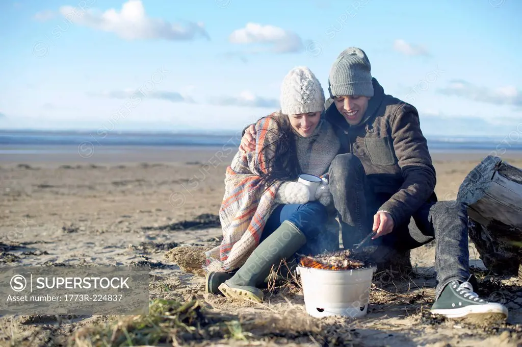 Young couple having bbq on beach, Brean Sands, Somerset, England
