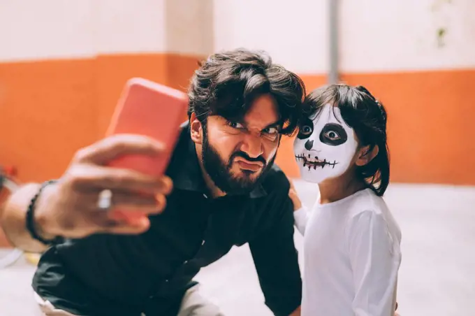 Girl and father taking Halloween selfie