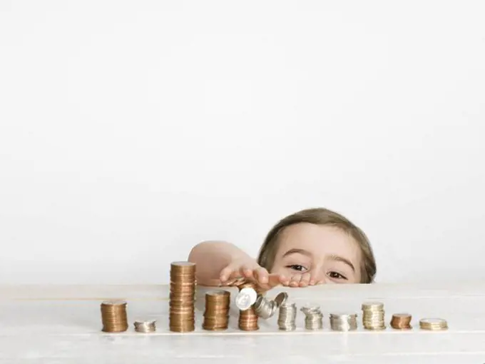 Girl stacking coins on counter