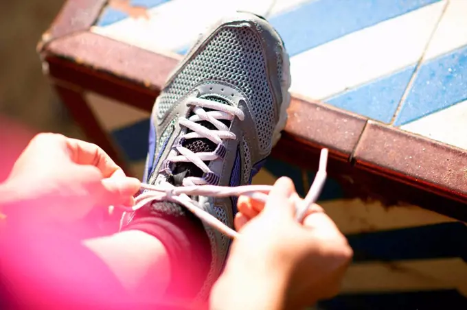 Point of view shot of mature woman leg raised tying shoelace