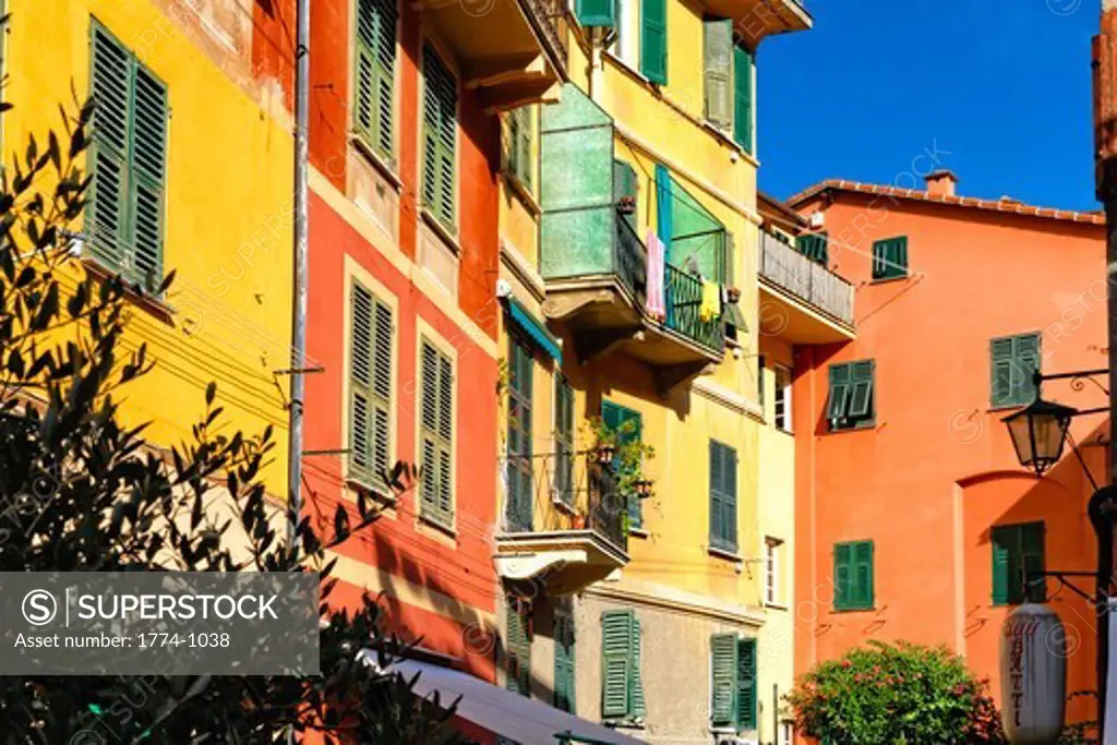 Italy, Liguria, Portofino, Low angle view of pastel colored house facades with shutters and small balconies
