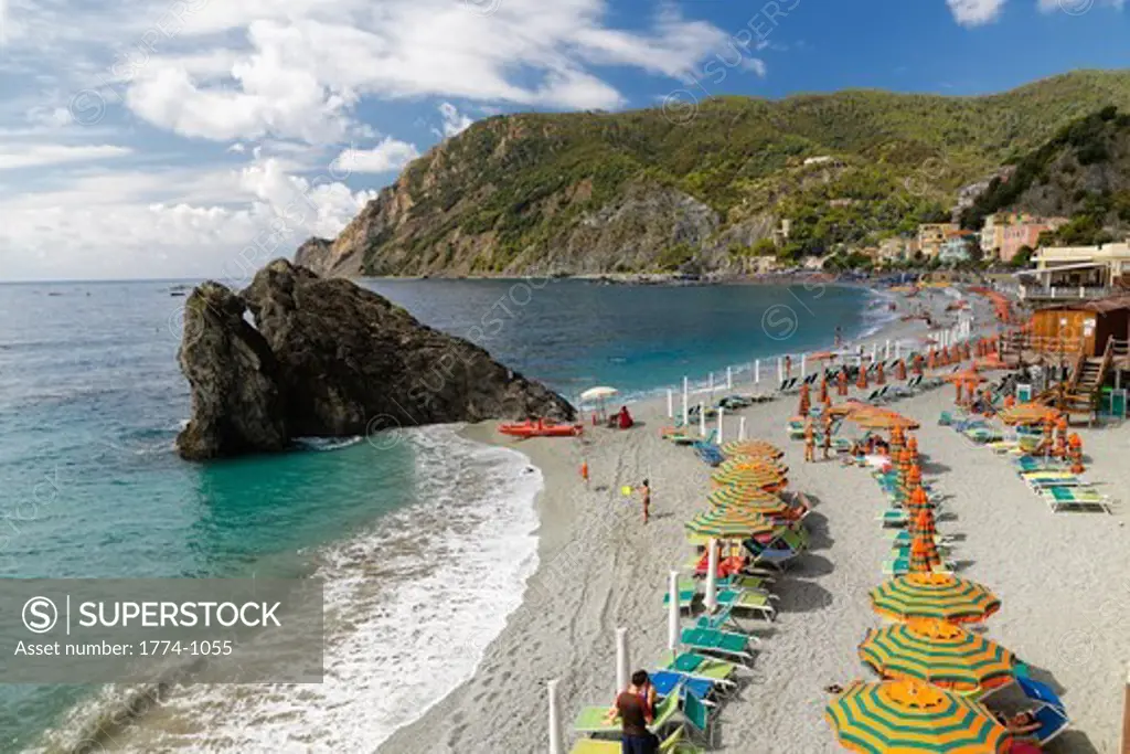Italy, Liguria, Cinque Terre, Monterosso Al Mare, High angle view of beach with umbrellas and lounge chairs lined up