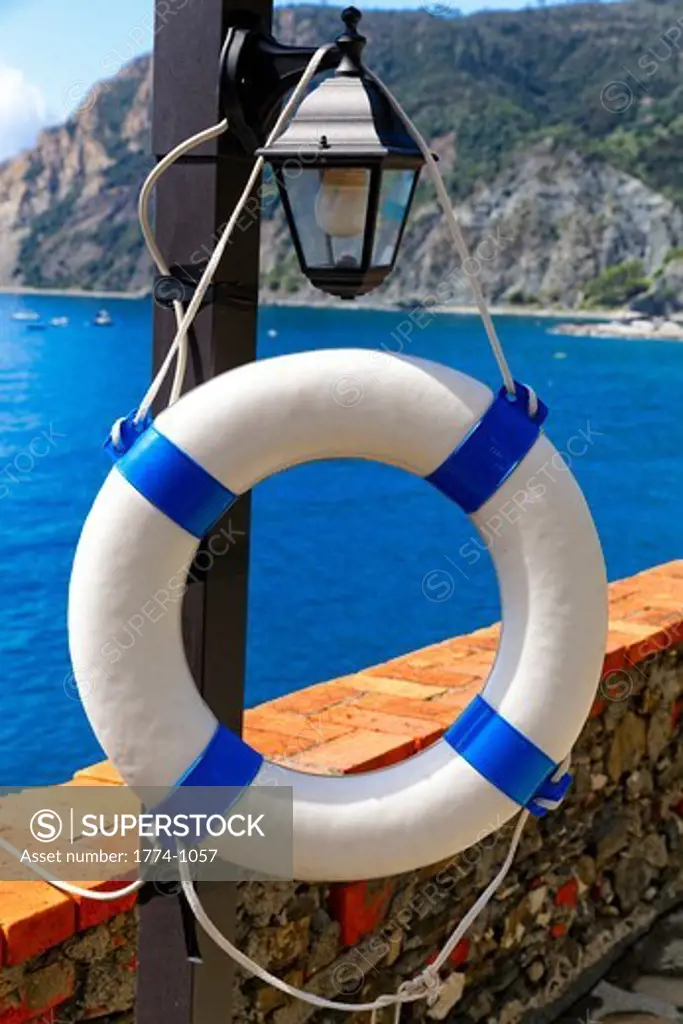 Italy, Liguria, Cinque Terre, Monterosso Al Mare, Close up view of life preserver hanging on lamppost along coast