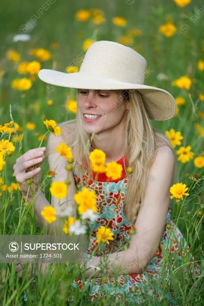 Young model holding a wildflower in a meadow, New Jersey, USA