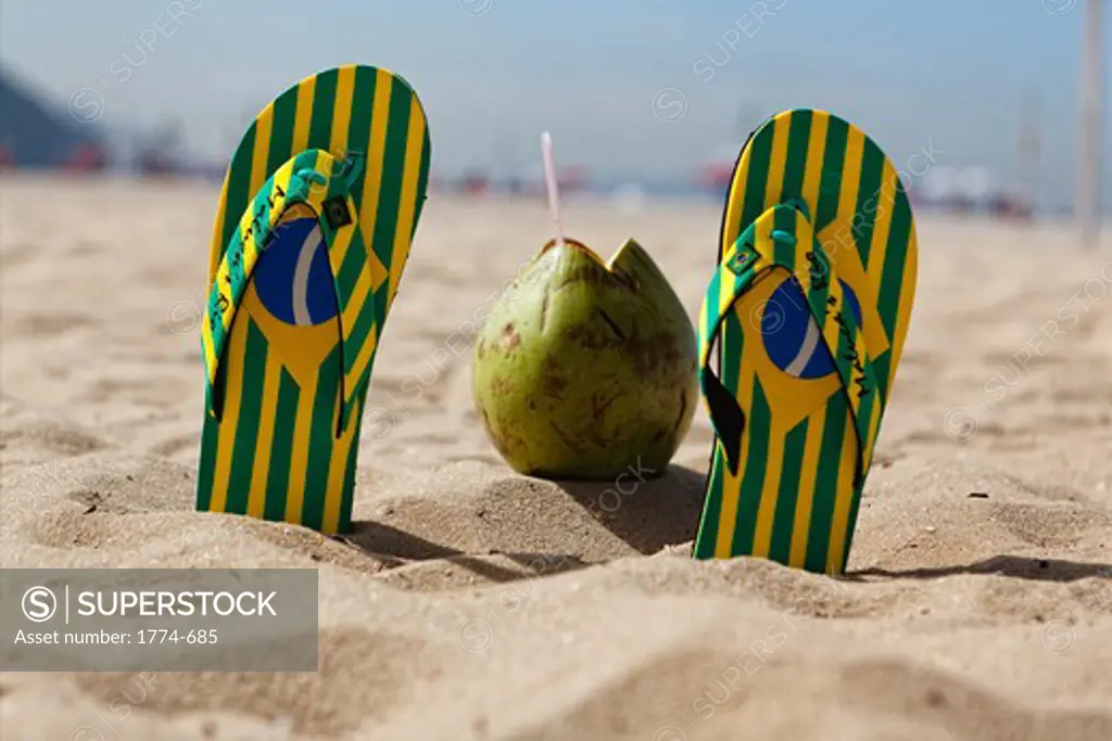 Brazil, Rio de Janeiro, Copacabana Beach, Flip-Flops and Coconut in sand