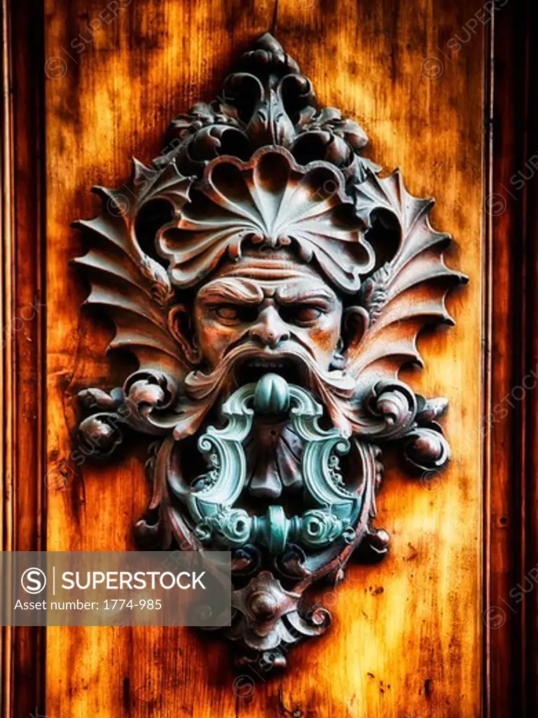 Italy, Tuscany, Florence, Close up view of angry man face door knocker