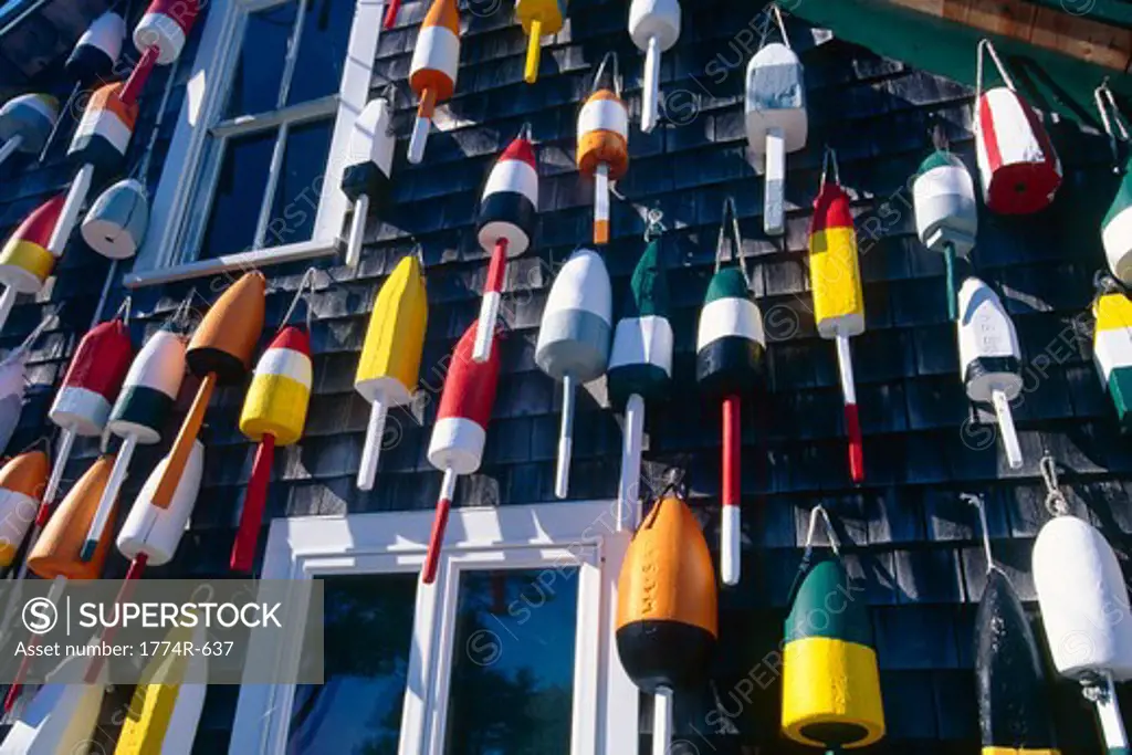 USA, Maine, Colorful lobster buoys hanging on wall of house