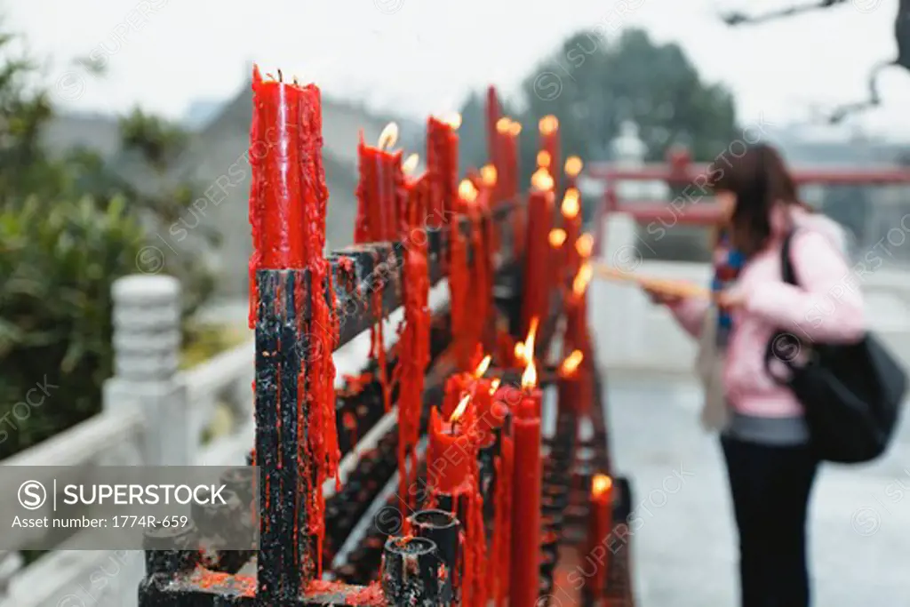 China, Shaanxi, Xian, Woman lighting candle at Big Wild Goose Pagoda