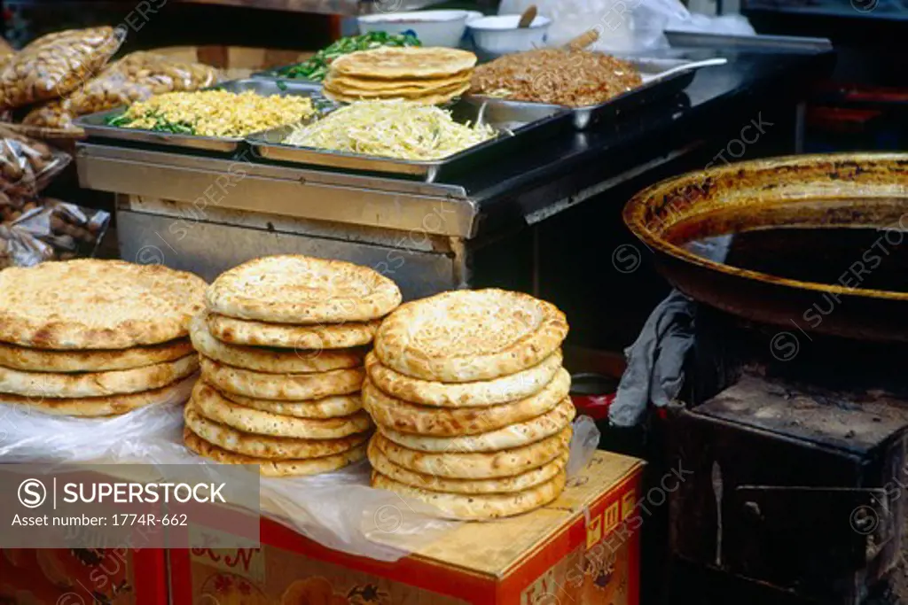 China, Xian, Stack of flat bread and toppings at outdoor food market at Muslim Street