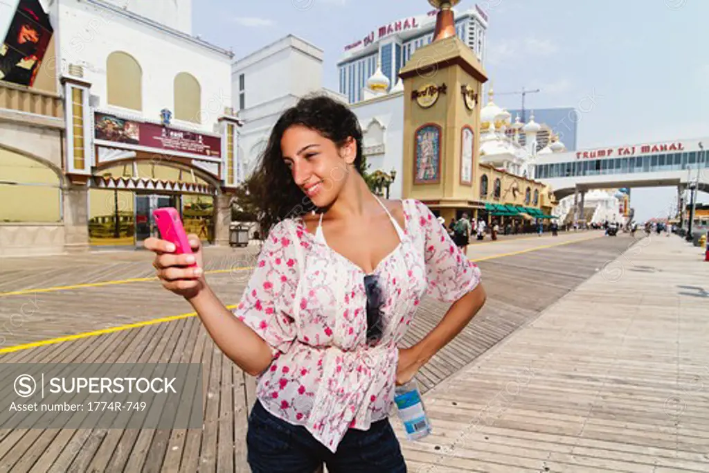 USA, New Jersey, Atlantic City, Boardwalk, Woman Checking Messages on Smartphone