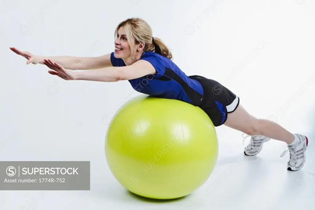 Woman Lying on Belly on Exercise Ball and Stretching