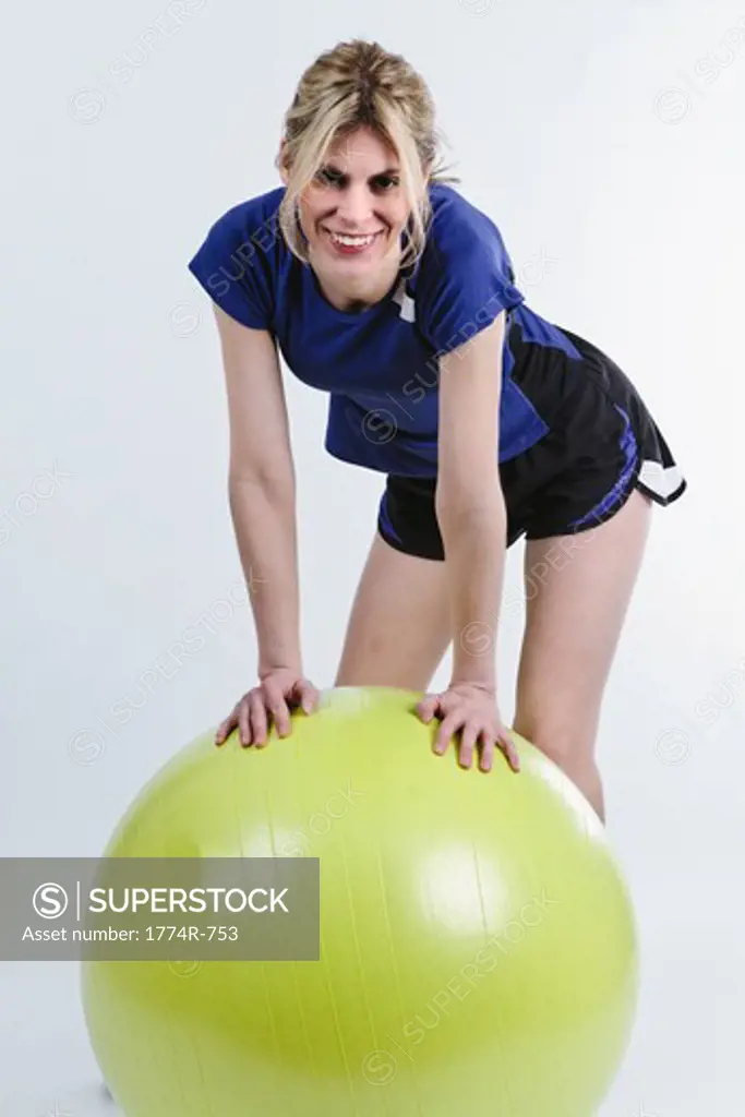 Woman Leaning on Exercise Ball while Working out