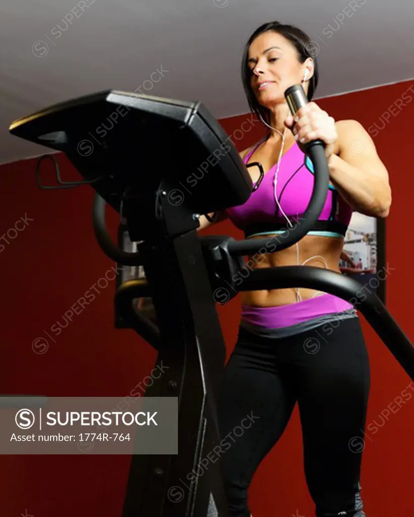 USA, New Jersey, Low Angle  View of Fit Woman  Exercisingin  Gym on Cardio Equipment