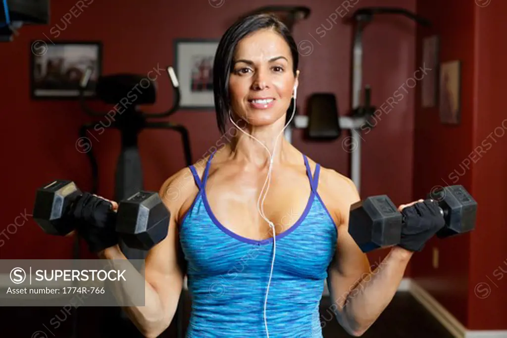 USA, New Jersey, Close Up View of  Fit Mid Adult Woman Performing Biceps Curls in Gym